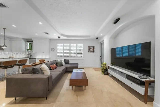 a living room with furniture a flat screen tv and a window