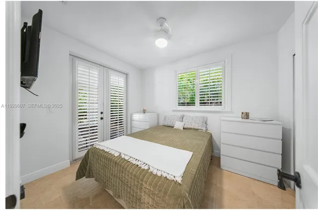 a bedroom with a bed and a flat tv screen on a dresser