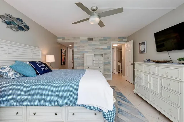 a spacious bedroom with a bed and a flat screen tv