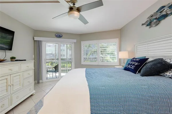 a large bedroom with a bed and flat tv screen on dresser