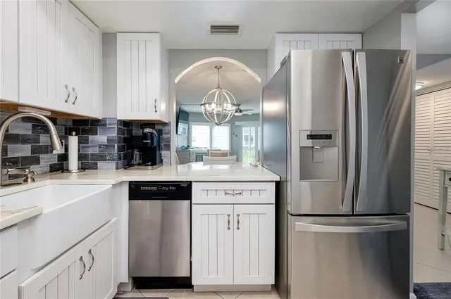 a kitchen with white cabinets and stainless steel appliances