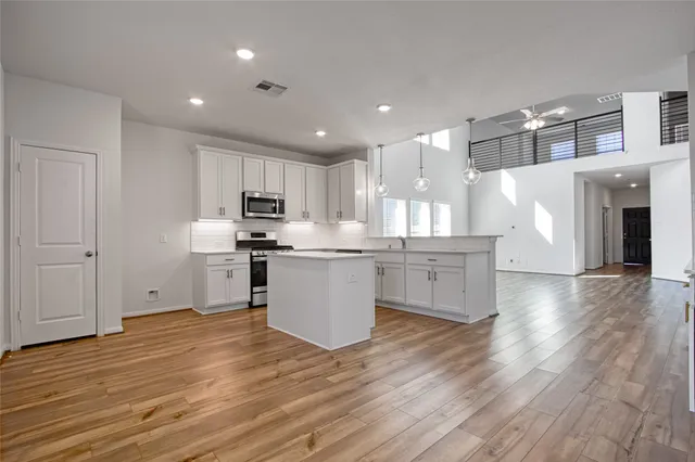 a kitchen with stainless steel appliances granite countertop a stove a sink and a refrigerator