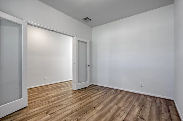 a view of an empty room with wooden floor