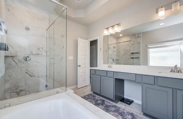 a bathroom with a double vanity sink mirror and shower