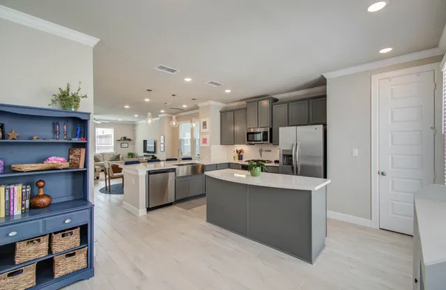 a kitchen with stainless steel appliances kitchen island granite countertop a refrigerator and a sink