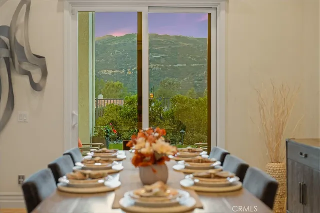 a dining room with furniture and a floor to ceiling window