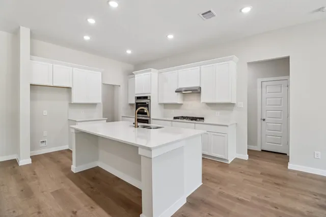 a kitchen with stainless steel appliances a sink stove and refrigerator