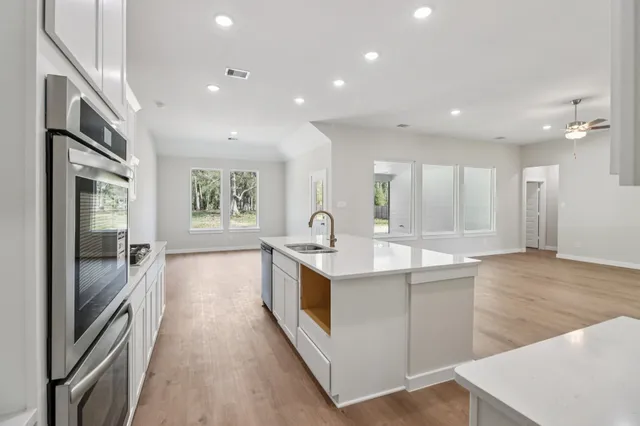 a large kitchen with stainless steel appliances a large counter top and a stove