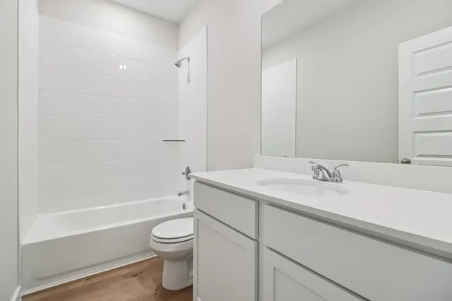 a bathroom with a granite countertop sink a toilet and shower