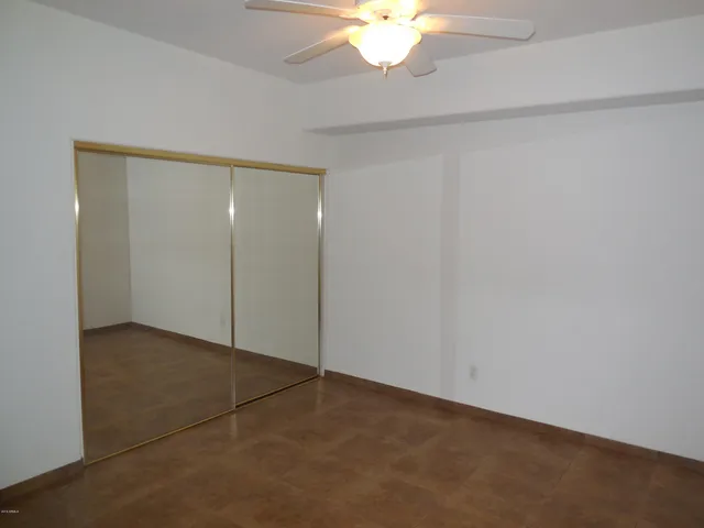 an empty room with a ceiling fan and a window