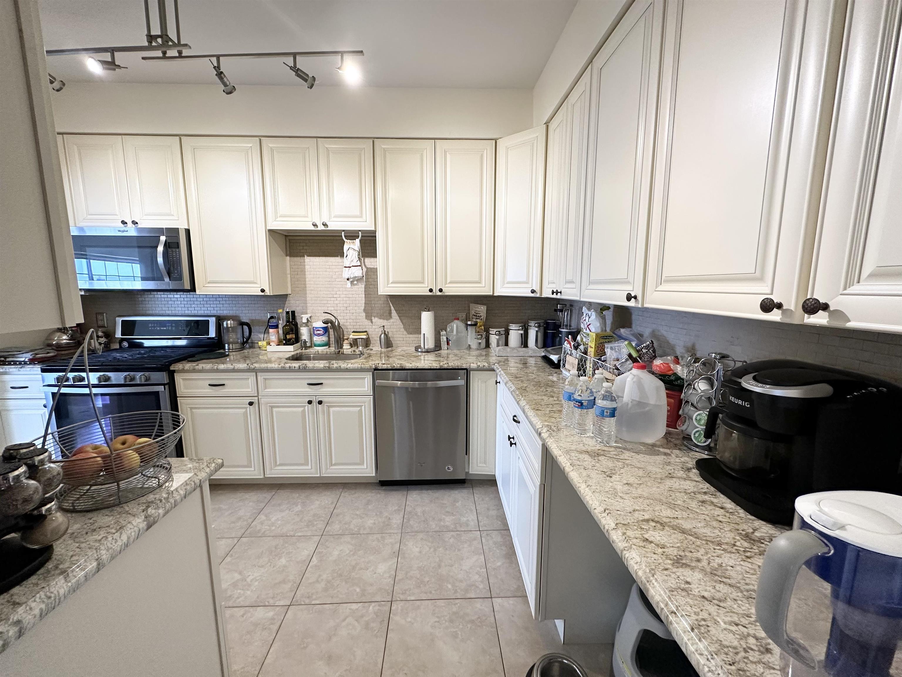 24 Bergen Ridge Road, Unit 1 North Bergen, NJ 07047 - Photo 5 of 17 a kitchen with a stove a sink a microwave and wooden cabinets