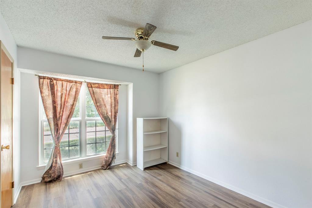 1936 Post Oak Drive Waco, TX 76705 - Photo 12 of 33 Unfurnished room featuring a textured ceiling, wood finished floors, and ceiling fan