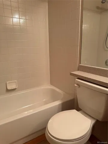 a white toilet and tub next to a bathroom sink