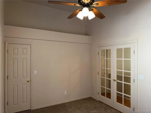 an empty room with windows and fan