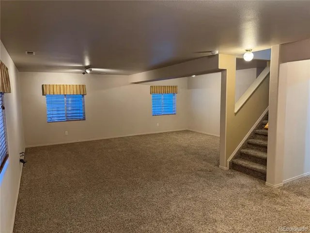 an empty room with windows and stairs