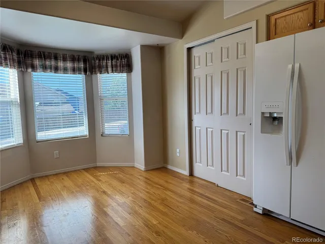 an empty room with wooden floor and a window