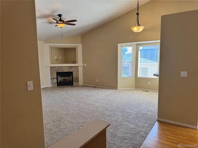 an empty room with a fireplace and chandelier