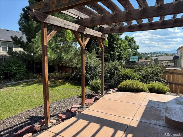 a view of a backyard with table and chairs under an umbrella