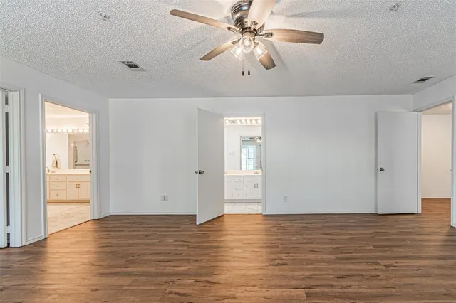a view of a room with wooden floor and ceiling fan