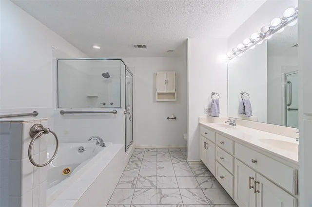 a spacious bathroom with a granite countertop double vanity sink mirror and bathtub