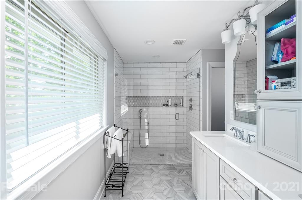 19007 Kailua Circle Tega Cay, SC 29708 - Photo 14 of 45 a bathroom with a sink a large mirror and a shower