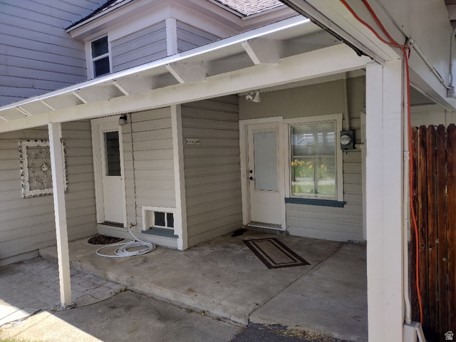 157 West 500 South Logan, UT 84321 - Photo 9 of 38 Covered concrete patio area with two entry doors, a side window, and horizontal siding