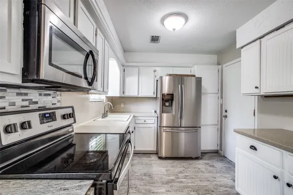 a kitchen with a stove a refrigerator and a sink