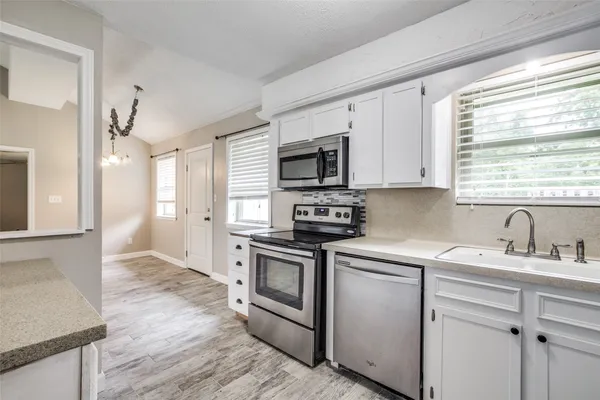 a kitchen with a sink stove and microwave