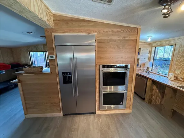 a kitchen with a stove and wooden floor