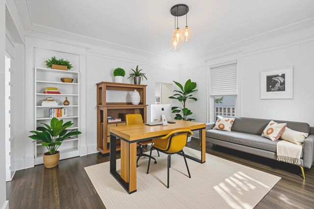 an empty room with wooden floor and fan