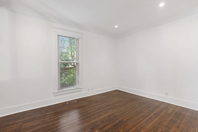 a view of a white house with a yard and large tree