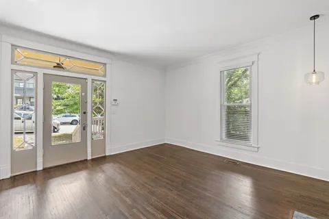 a kitchen with stainless steel appliances a refrigerator a sink dishwasher a stove and white cabinets with wooden floor