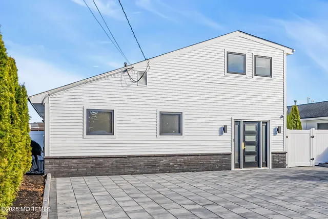 a view of a white house with a yard