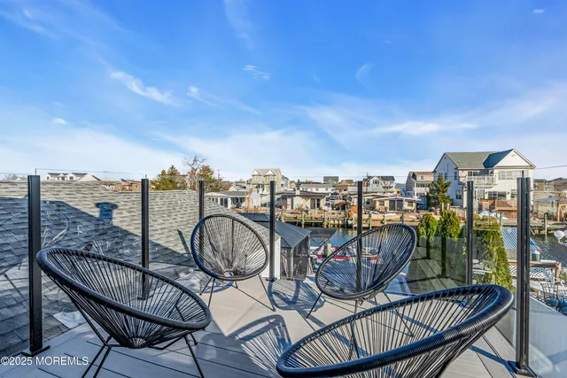 a view of a roof deck with couches and wooden floor