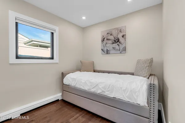 a bedroom with a large bed and a painting on the wall