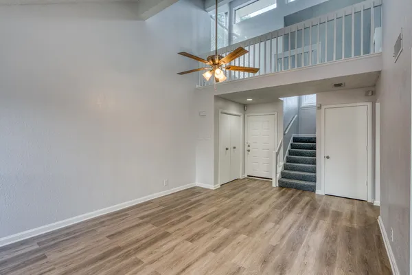 a view of a hallway with wooden floor and entryway