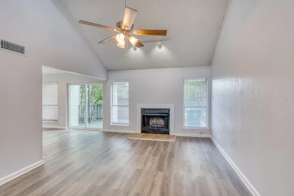 wooden floor fireplace and windows in an empty room