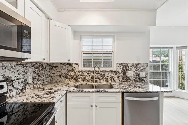 a kitchen with granite countertop a sink and a white stove