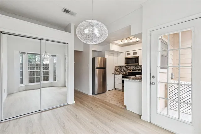 a view of a kitchen with refrigerator and wooden floor