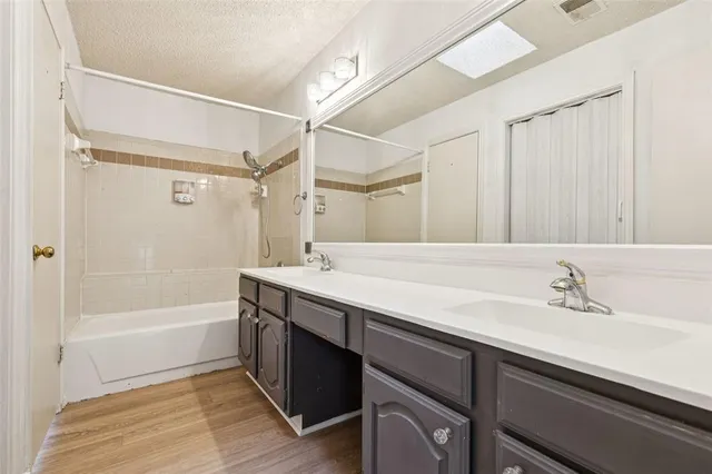 a bathroom with a tub sink shower and a mirror
