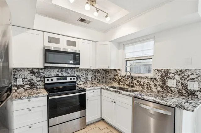 a kitchen with stainless steel appliances granite countertop a stove and a microwave
