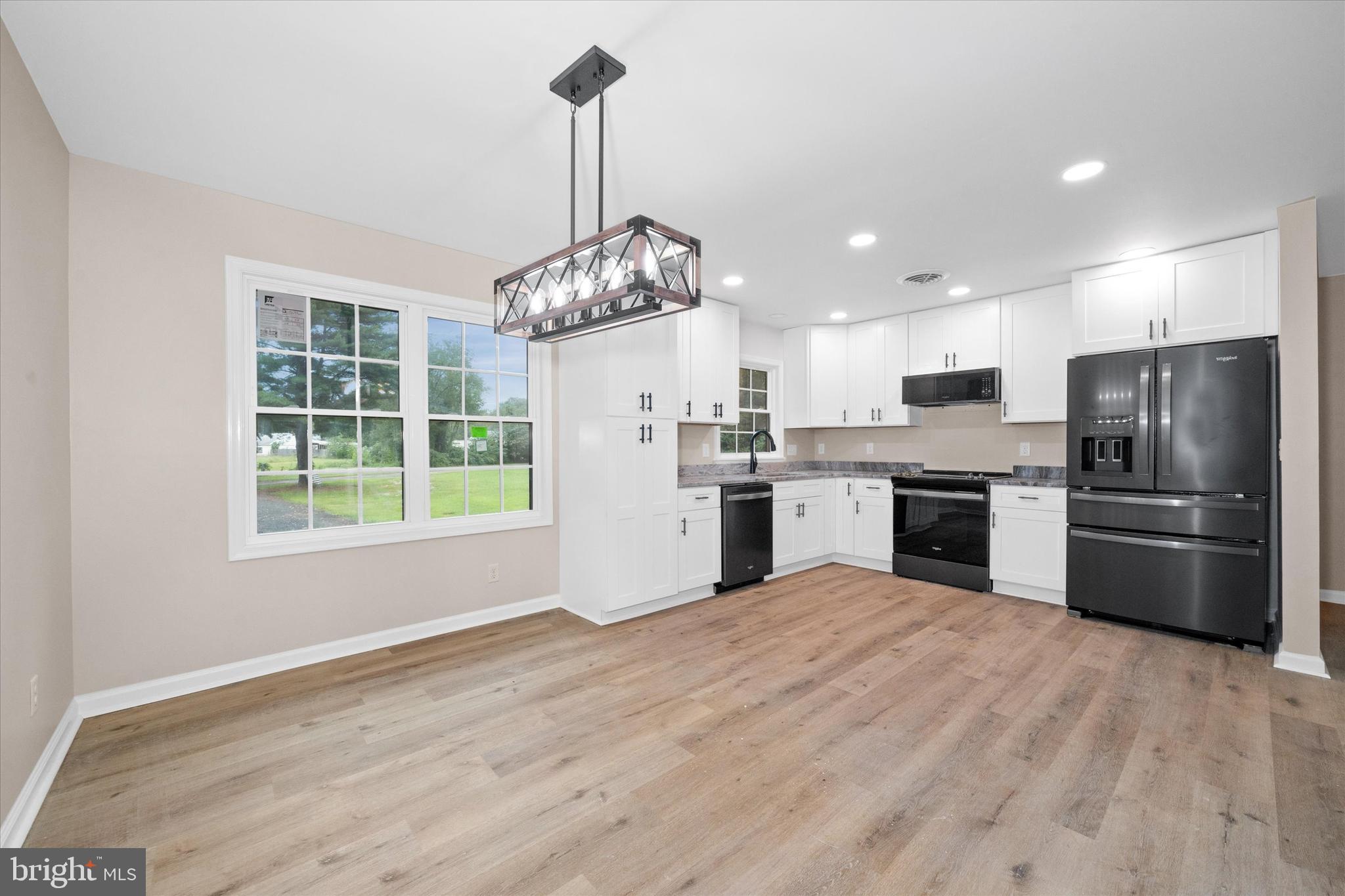 834 Willow Grove Road Felton, DE 19943 - Photo 11 of 48 a kitchen with stainless steel appliances granite countertop a refrigerator a sink dishwasher a stove and a sink with wooden floor