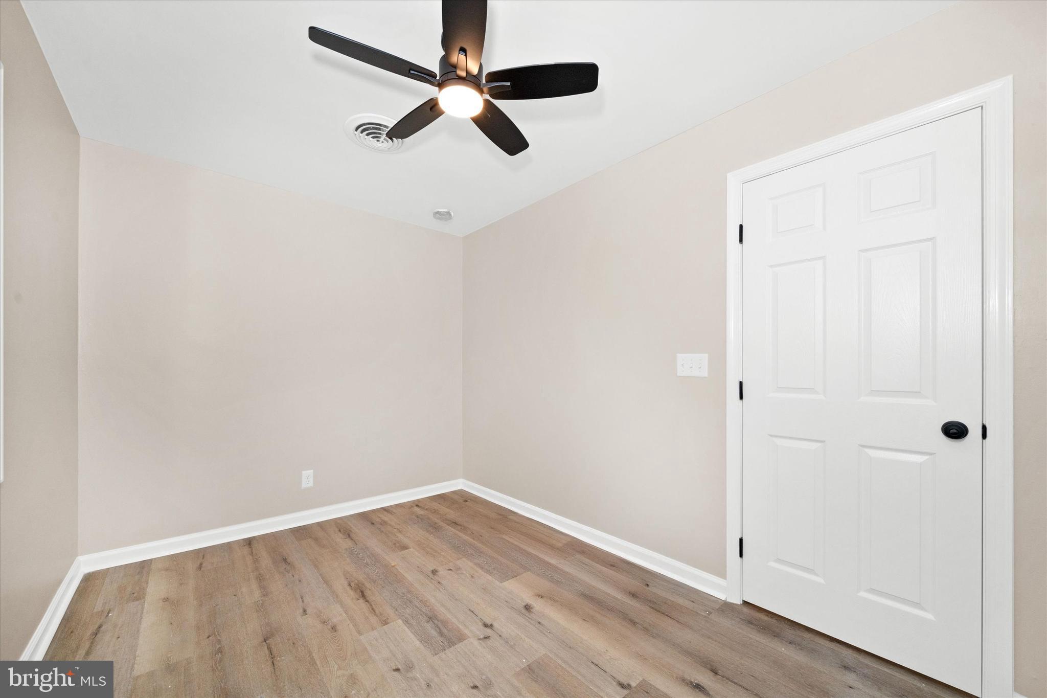 834 Willow Grove Road Felton, DE 19943 - Photo 23 of 48 an empty room with wooden floor ceiling fan and window