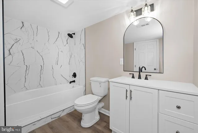 a view of empty room with wooden floor and windows