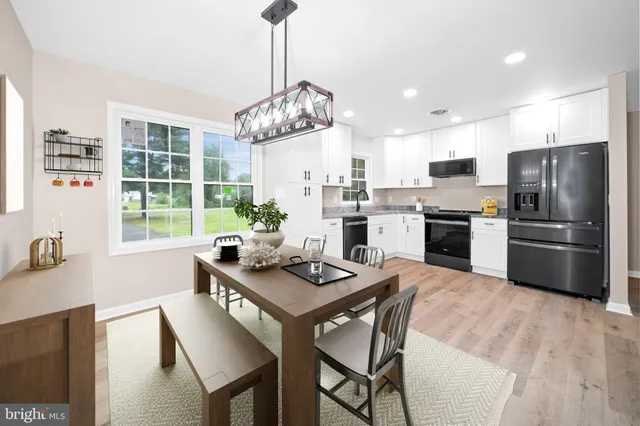 a kitchen with granite countertop a stove a sink dishwasher a refrigerator and a oven with wooden floor