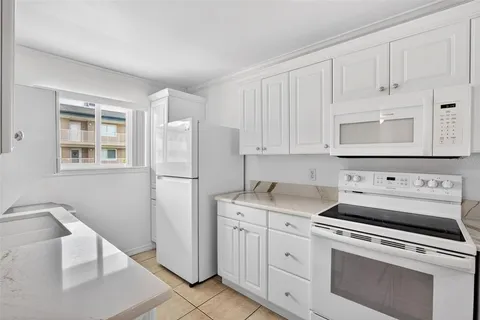 a large white kitchen with cabinets