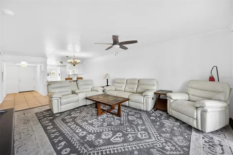 a living room with furniture a flat screen tv and a large window