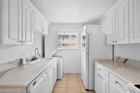 a kitchen with white cabinets and white appliances