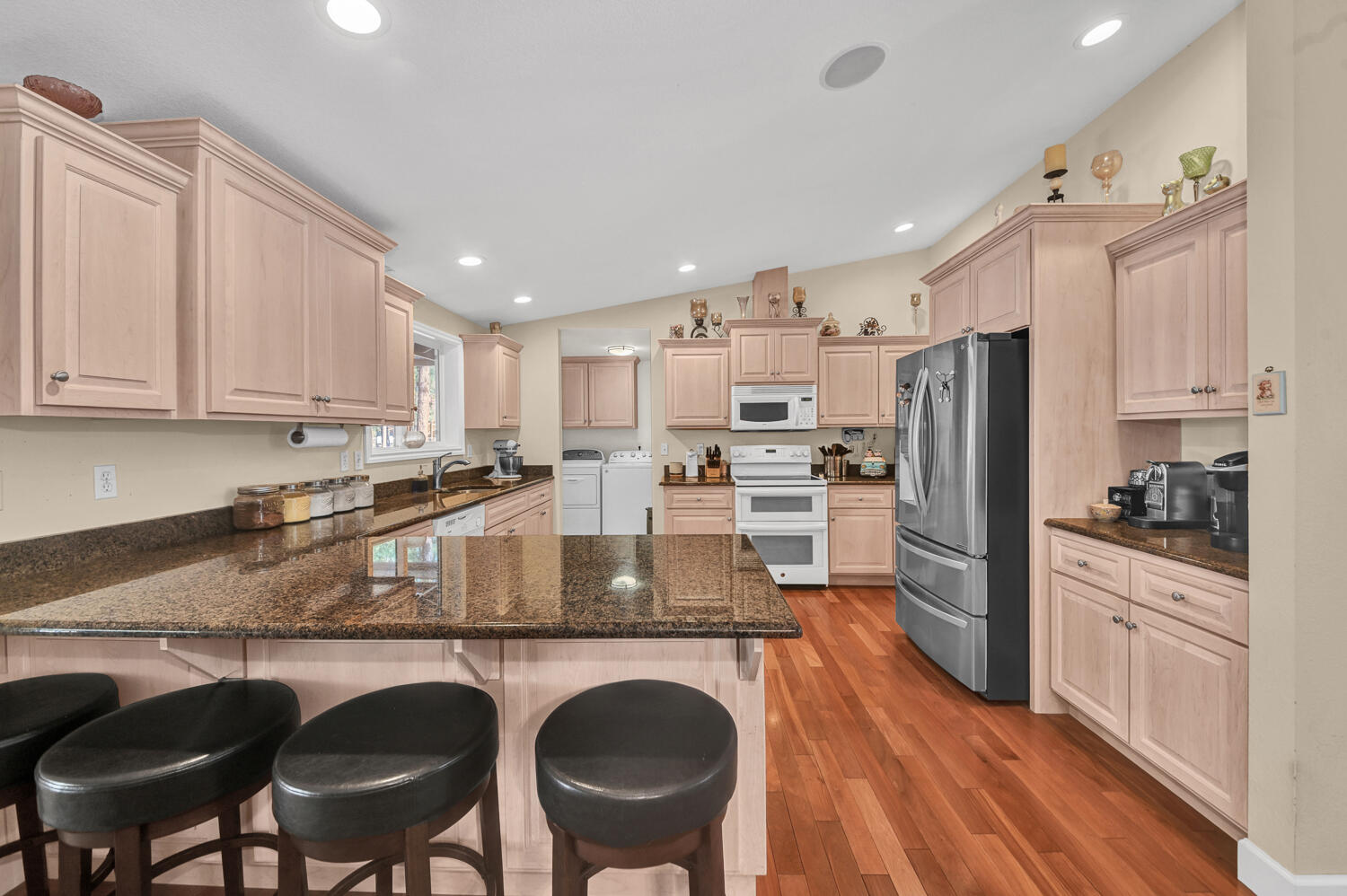 14840 Laurel Road La Pine, OR 97739 - Photo 8 of 32 a kitchen with stainless steel appliances granite countertop a table chairs sink refrigerator and cabinets
