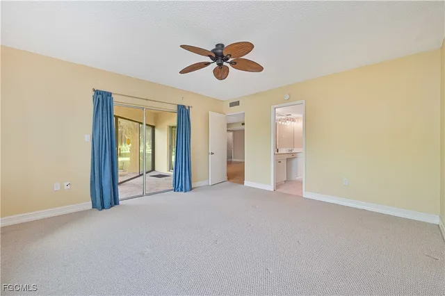 a view of a livingroom with a ceiling fan & windows